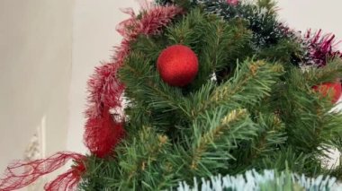 Noel ağacı. Noel ağacı ve kostüm süslerinin tepeden tırnağa güzel bir canlı kamera görüntüsü. Kırmızı takılar ve papyonlar yeşil sahte ladin üzerinde.