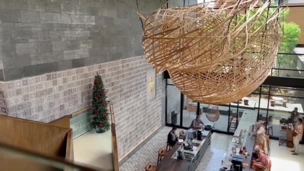 印度尼西亚巴厘- 20200年1月2日：星巴克咖啡馆大厅，人们与圣诞树在一起，现场拍摄了热饮和甜屁股与糖霜在盘子里的镜头. — 图库视频影像