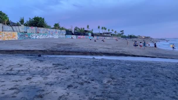 Krásná Oldmans pláž v tropickém ráji v modré hodině v oblasti Canggu Bali Indonésie. Pozadí městské betonové zdi na pláži oceánu po západu slunce. — Stock video