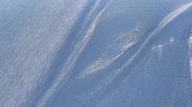 Endonezya 'nın Bali adasında, Canggu' daki siyah bir kumsalda nehrin aktığı gri ve sarı kumla karışan güzel siyah volanik snad. Deniz kenarındaki kumun doğal dokusu.