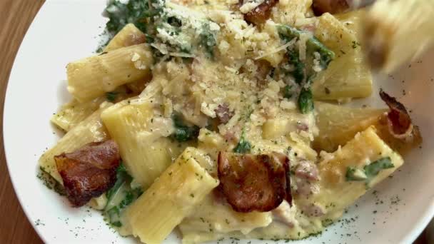 Pov view het eten van heerlijke pasta carbonara met gebakken varkensspek en spinazie. Italiaanse keuken close-up. Zelfgemaakte romige pasta met vlees. — Stockvideo