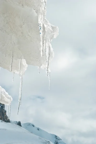 Eiszapfen auf einem Dach mit Schnee. — Stockfoto