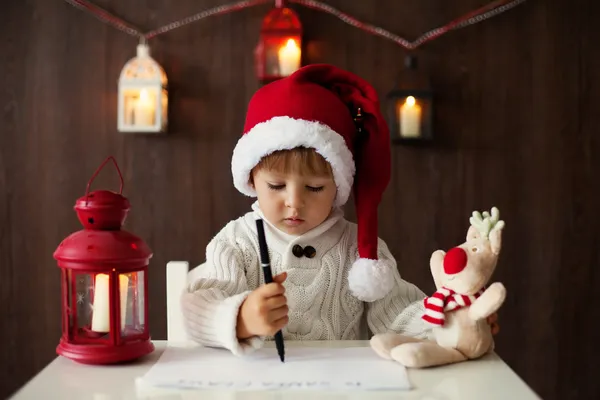 Маленький мальчик на Рождество, пишет письмо Санте — стоковое фото