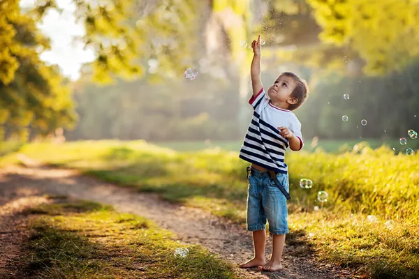 Junge, der mit Seifenblasen spielt — Stockfoto