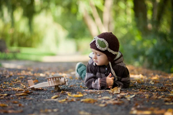 Herbstporträt eines Jungen mit Flugzeug in einem Park — Stockfoto