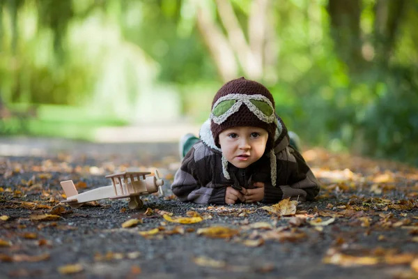 Herbstporträt eines Jungen mit Flugzeug in einem Park — Stockfoto