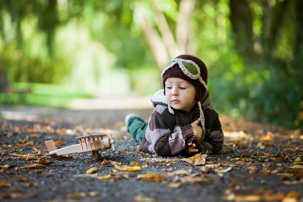 Autumn portrait of a boy with airplane in a park — Stock Photo, Image