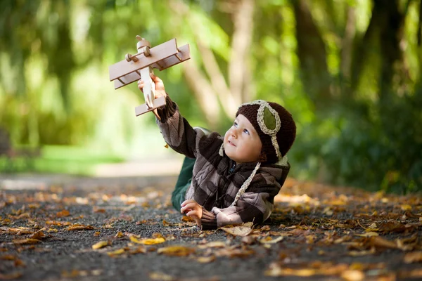 Portrait d'automne d'un garçon avec avion dans un parc — Photo