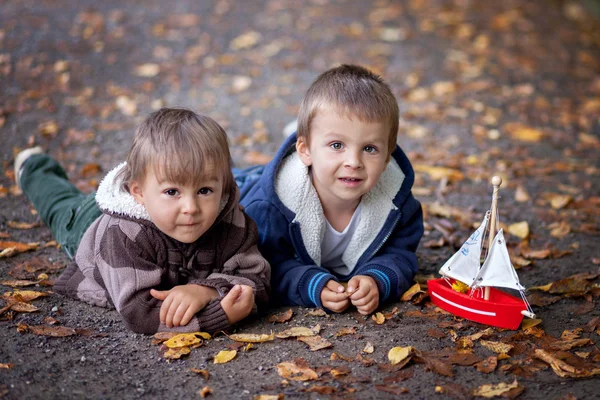 Two boys in a a park with a boat — Stock Photo, Image