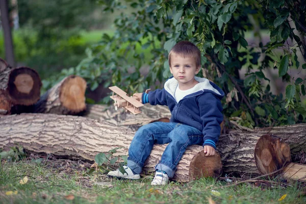 Autumn portrait of a boy with airplane in a park — Stock Photo, Image
