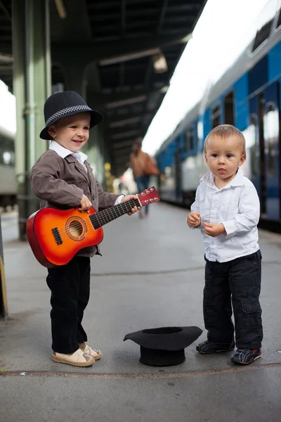 Мальчик с гитарой на железнодорожной станции — стоковое фото