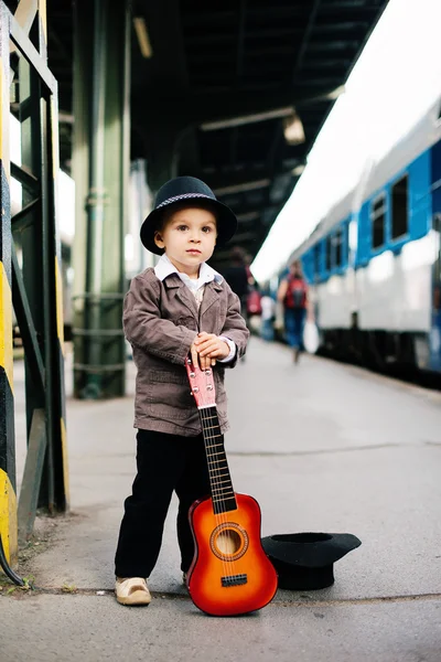 Jongen met een gitaar op een spoorwegstation — Stockfoto