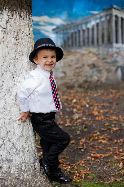 Мальчик, одетый в костюм и галстук, позирующий — стоковое фото