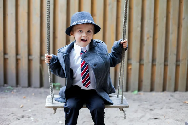 Мальчик, одетый в костюм и галстук, позирующий — стоковое фото