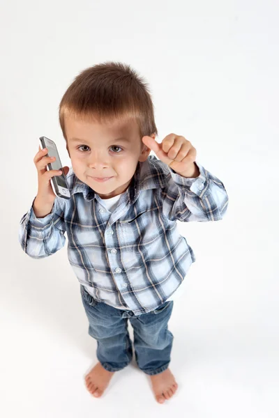 Kisfiú, beszél a telefonon, a hüvelykujját, — Stock Fotó