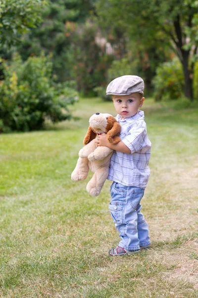 Мальчик с пушистой собачьей игрушкой — стоковое фото