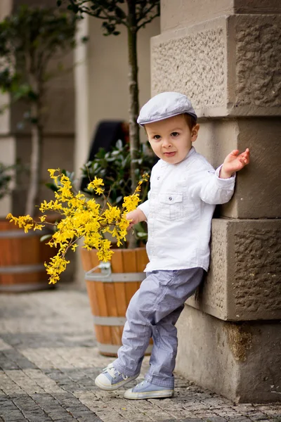 Menino encantador com flores, esperando por sua senhora — Fotografia de Stock