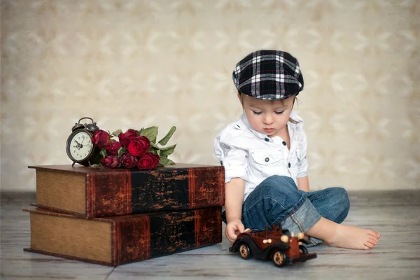 Chłopiec z książek, kwiaty i zegar — Zdjęcie stockowe