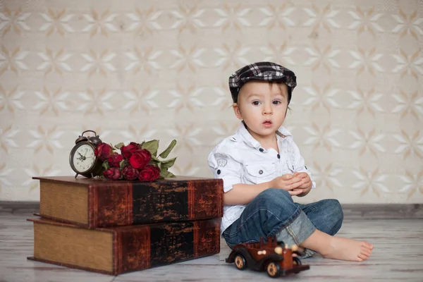 Chłopiec z książek, kwiaty i zegar — Zdjęcie stockowe