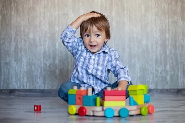 Boy, playing with wooden train — Stock Photo, Image