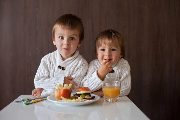 Два мальчика, едят фруктовый сэндвич — стоковое фото