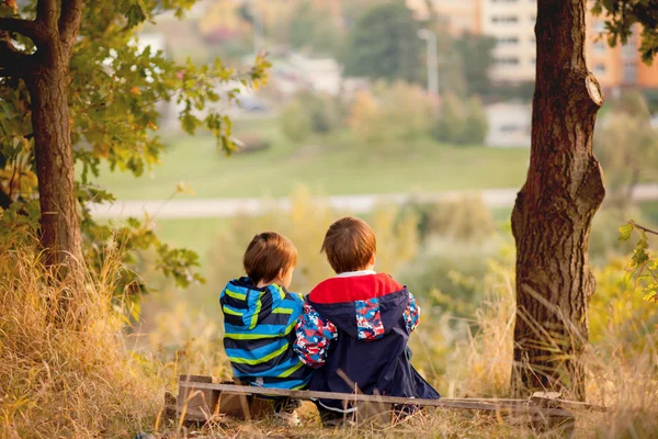 Два мальчика, сидящие на скамейке — стоковое фото