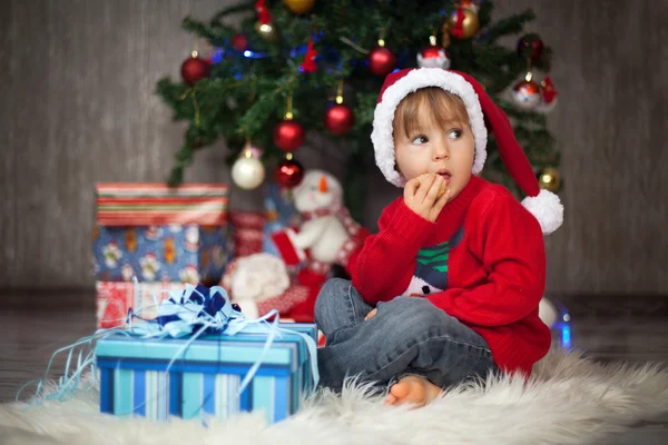 Liten pojke öppning presenterar för chrismas — Stockfoto