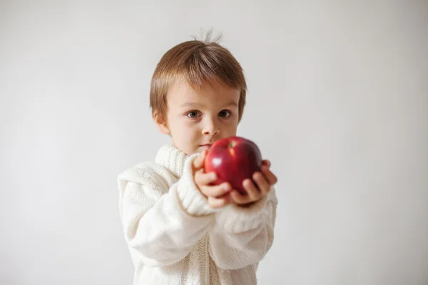 Мальчик, держит яблоко — стоковое фото