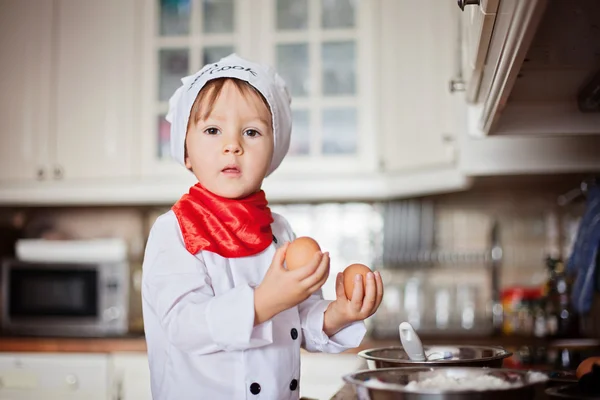 Маленький мальчик, печет кексы — стоковое фото