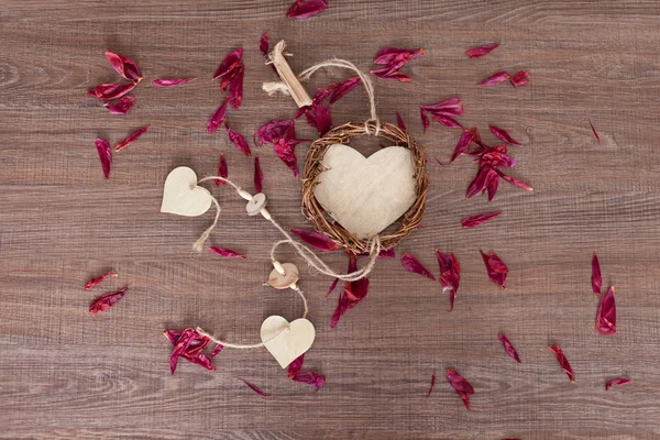 Wooden heart with rose leaves — Stock Photo, Image