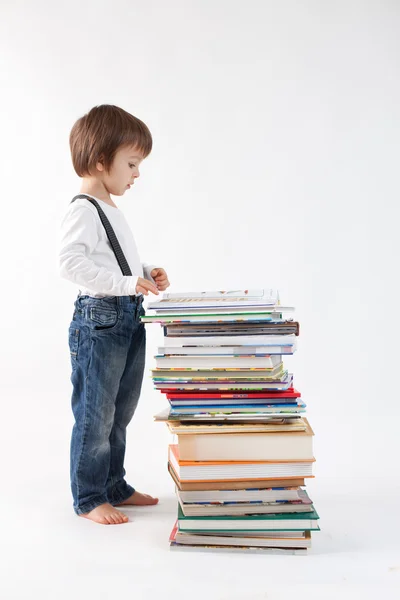 Мальчик с грудой книг — стоковое фото