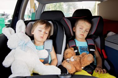 Two boys in car seats, travelling  clipart