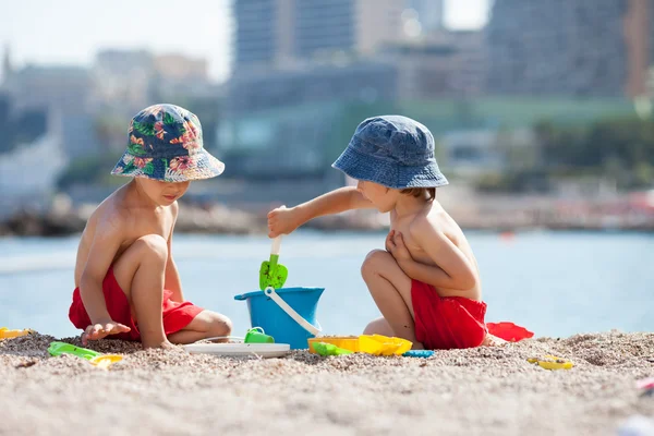 Два симпатичных ребенка, играющих в песок на пляже — стоковое фото