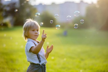 Gün batımında parkta oynayan sevimli anaokulu çocuğu.