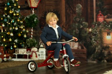 Sevimli çocuk, bavul ve oyuncak ayı tutuyor, tatilleri evde bekliyor, stüdyo çekimi.