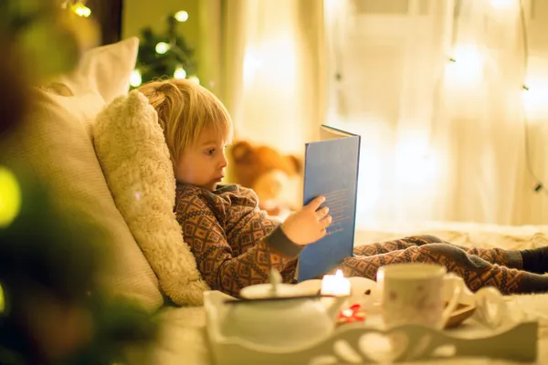 Przytulna Atmosfera Świąteczna Domu Dziecko Siedzące Łóżku Czytające Książkę Cieszące — Zdjęcie stockowe