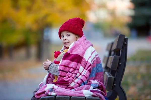 幸せな子供は 晴れた日に秋の公園で遊んで 葉や葉を彼の周りに残し リンゴを食べる ストック画像
