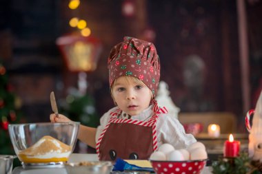 Tatlı sarışın çocuk, yeni yürümeye başlayan çocuk, evde Noel kurabiyesi pişirmek, eğlenmek.