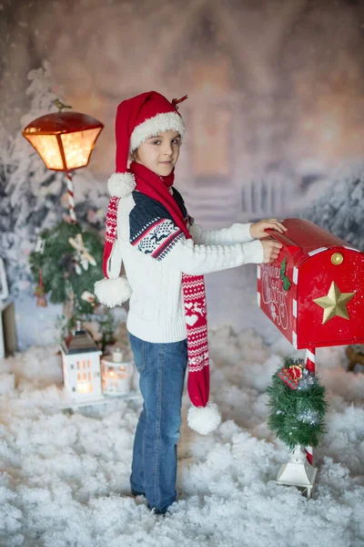 可爱的孩子 小学生 用圣诞邮筒寄信给桑塔 给他周围的圣诞装饰品 户外射精 室外飞雪 — 图库照片