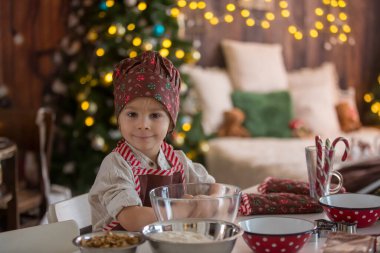 Tatlı sarışın çocuk, yeni yürümeye başlayan çocuk, evde Noel kurabiyesi pişirmek, eğlenmek.