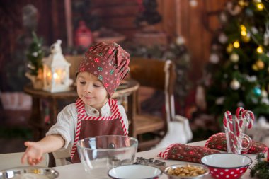 Tatlı sarışın çocuk, yeni yürümeye başlayan çocuk, evde Noel kurabiyesi pişirmek, eğlenmek.
