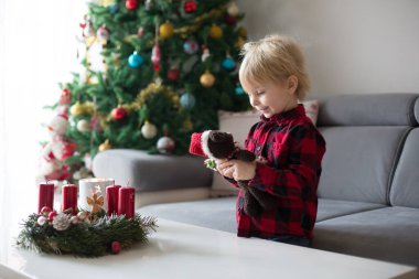 Küçük tatlı sarışın çocuk, evde çelenk yapıyor, dekore ediyor.