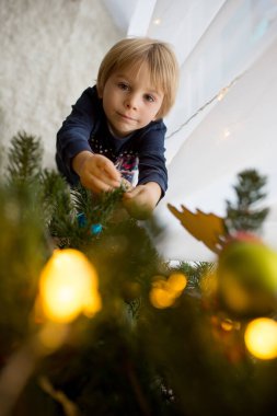 Sevimli çocuk, oğlum, Noel ağacını oyuncaklarla süslüyorsun.