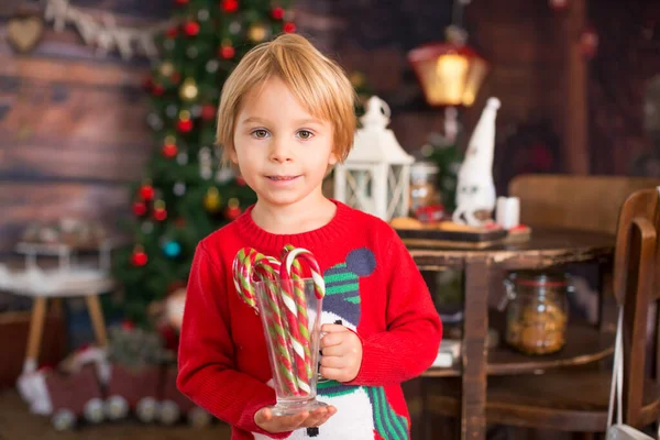 金发碧眼的孩子 蹒跚学步的孩子 圣诞节在家里玩的开心 玩着五彩缤纷的糖果手杖 — 图库照片