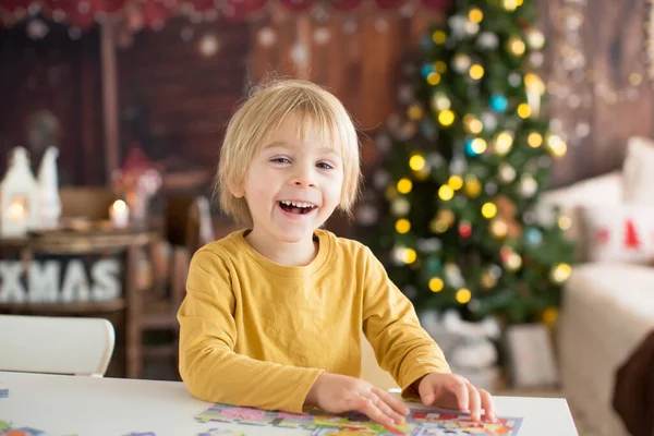 ブロンドの子供 幼児の男の子 クリスマスに家で楽しみ パズルを組み立て 晴れた日を楽しむ — ストック写真