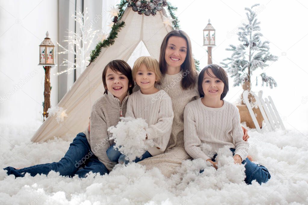 Happy family, children and mom, enjoying christmas together in cozy home, decorated with christmas decoration