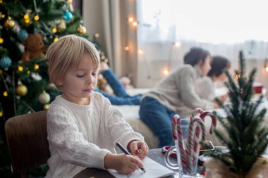 Mutlu aile, çocuklar ve anne, Noel süslemeleri ile süslenmiş rahat bir evde birlikte Noel 'i kutluyoruz.