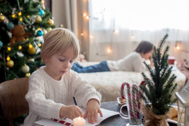 Mutlu aile, çocuklar ve anne, Noel süslemeleri ile süslenmiş rahat bir evde birlikte Noel 'i kutluyoruz.