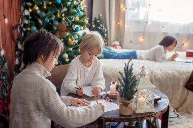 Mutlu aile, çocuklar ve anne, Noel süslemeleri ile süslenmiş rahat bir evde birlikte Noel 'i kutluyoruz.
