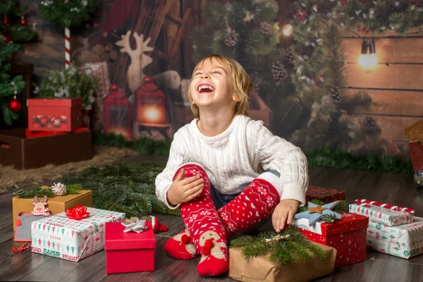 Tatlı çocuk, yerde bir sürü süslü hediyeyle yatıyor.